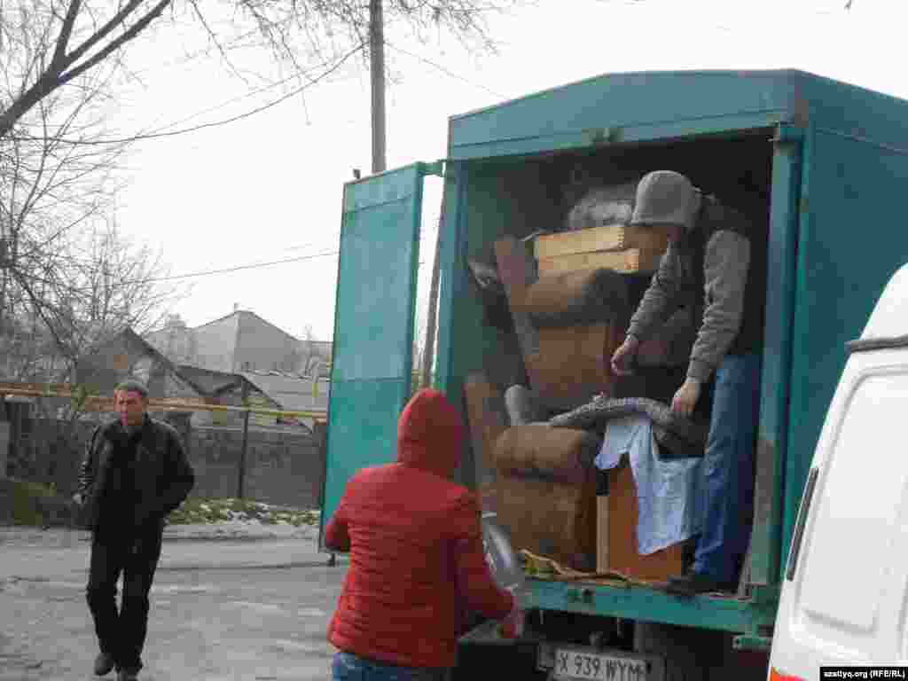 Тұрғындар өрттен аман қалған мүліктерін көлікке тиеп жатыр. Шымкент, 21 желтоқсан 2014 жыл.